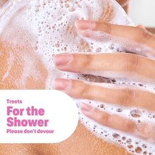 Hands lathering soap bubbles under running water on a shower body wash.