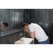 Man rinsing face at sink, using face wash