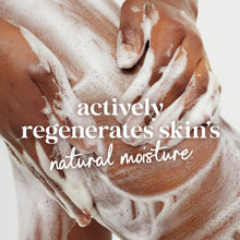 Hands with white body wash foam lathered on skin, close-up