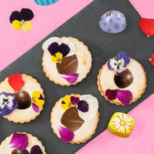 Assorted Easter milk chocolate candies on a tray, with edible flower decorations