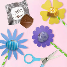 Milk chocolate candy assortment with Dove wrappers, flowers, and scissors
