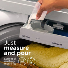 Fabric softener cup being poured into washer dispenser drawer labeled Softener