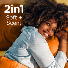 Person wrapped in a light blue towel, emphasizing soft fabric with 2-in-1 scent