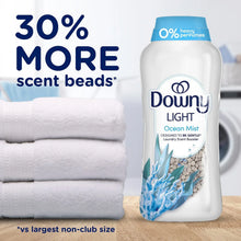 Ocean Mist scent booster beads bottle with 30% more claim, beside folded towels