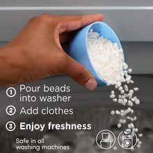 Laundry scent booster beads poured from a blue scoop into the washer