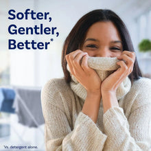Gentle fabric softener, woman hugging a towel to her face