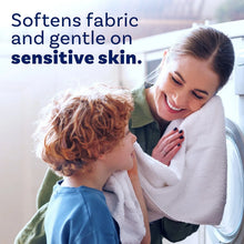 Downy Soft Free & Gentle fabric softener with caregiver and child cuddling near washer