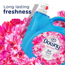 Blue liquid fabric softener bottle with pink floral label and pink flowers