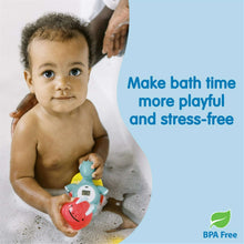 Baby holding a teal dinosaur floating bath thermometer with LCD temperature screen in bubble bath.