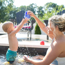 Blue elephant bath watering toy being held while spraying water during bath play