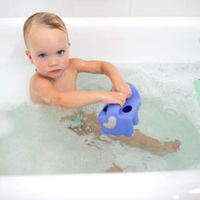Baby bathing in a tub holding a blue elephant bath watering toy