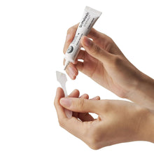 Eye bag cream tube held in hands, white squeeze tube with Dr. Melaxin label