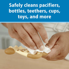 Baby cleaning wipes used on pacifiers and toys, with hands holding white wipe.