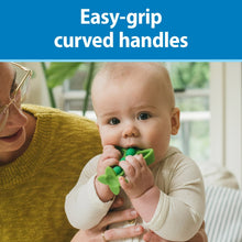 Green silicone peapod teether with easy-grip curved handles in a baby’s hands.