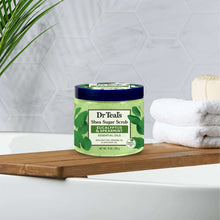 Dr Teal's shea sugar body scrub jar with blue lid and green scrub