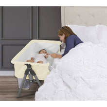 Ivory bedside sleeper bassinet with canopy net, open side, on metal legs