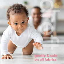 Baby in white onesie with gentle and safe on all fabrics ad text overlay