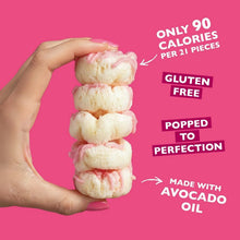 Stack of frosted strawberry mini rice cakes held in a hand
