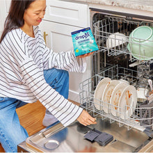 Ultrawash dishwasher detergent pacs box in hand near open dishwasher