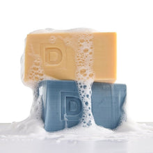 Stacked orange and blue soap bricks with embossed letters on front