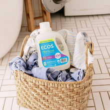 Lavender hypoallergenic laundry detergent bottle in wicker basket with folded clothes