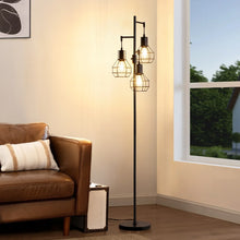 Black metal standing floor lamp with four caged shades and exposed warm bulbs