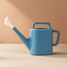 Blue resin watering can with wide carry handle and angled spout