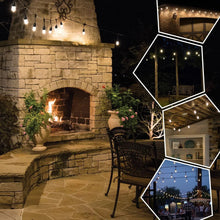 Warm white cafe string lights hung around a stone patio
