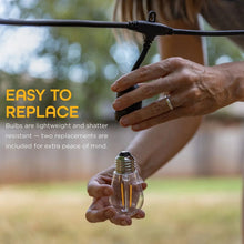 Hand holding warm clear LED bulb for black outdoor café string lights