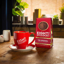 Eight O'Clock medium-dark roast ground coffee bag with red mug and saucer