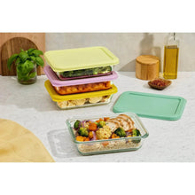 Glass meal prep containers with open clear base and lime, purple, and mint lids
