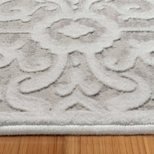 Close-up of light gray rug with white floral medallion pattern