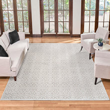 Light gray area rug with white ornate floral pattern, short fringe edges