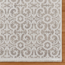 Light gray area rug with repeating ivory damask pattern and short fringe edges