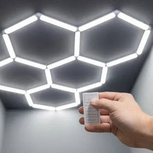 Hex ceiling light panels with remote control in hand