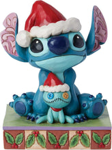 Blue Stitch stone-resin figurine wearing a red Santa hat with white trim