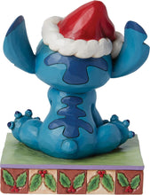Blue Stitch stone-resin figurine with red Santa hat, arms out, on decorated base
