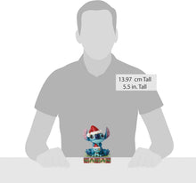 Small blue Stitch stone-resin figurine with red Santa hat on green-and-red base