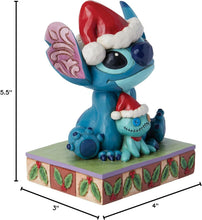 Blue Stitch stone-resin figurine in red Santa hat holding a stitched doll on base