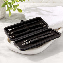 Metal acne blemish tool set tools in open black case on a white towel