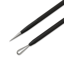 Metal acne extraction tools with black textured handles, pointed tips, and loop end