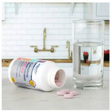 Multivitamin bottle with pink tablets and glass of water