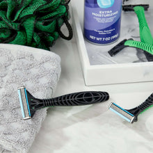 3-blade disposable razors with green handles and black cartridges on sink counter