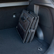 Black trunk organizer with divided bins and elastic straps for securing items