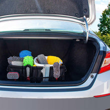Black trunk organizer with multiple fabric sections holding small accessories
