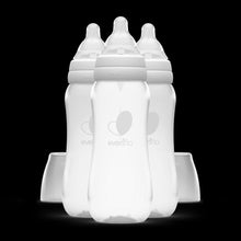 Set of clear plastic baby bottles with standard neck nipples and white caps