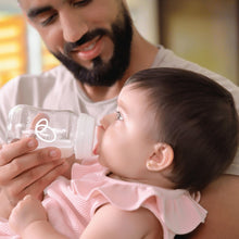 Parent holding an Evenflo Balance+ bottle as a baby drinks