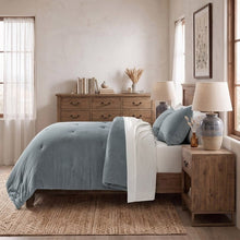 Blue mini waffle plush comforter with white reverse and matching pillows on a bed