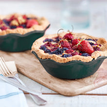Mini pie dish set with fruit tart in dark green scalloped shell bowls