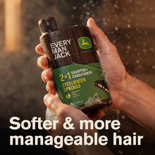 Hand holding 2-in-1 shampoo+conditioner bottle, dark bottle with green label and cap
